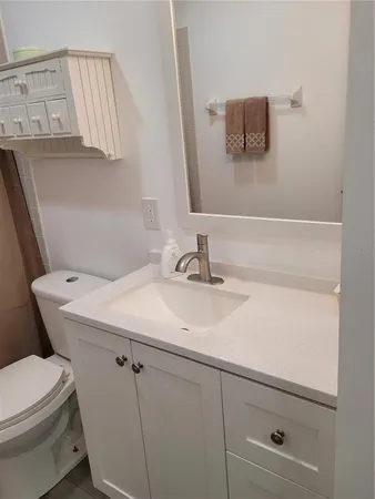 a bathroom with a sink toilet and mirror