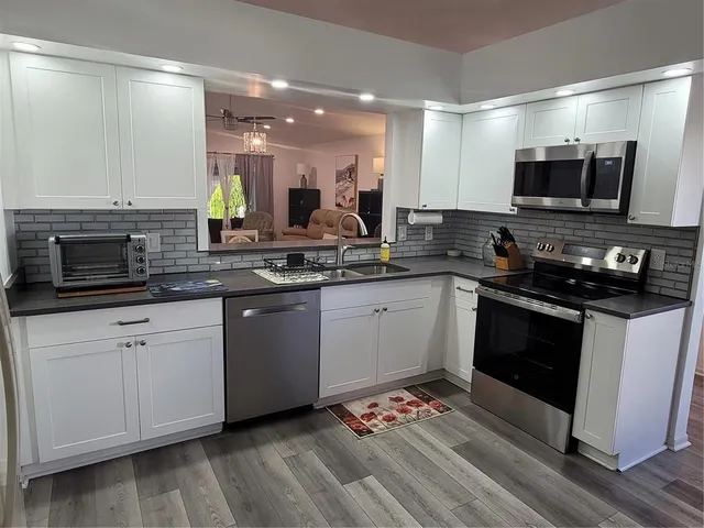 a kitchen with a sink stove and microwave