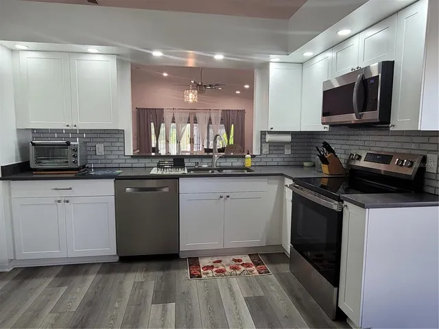 a kitchen with a sink stove and microwave