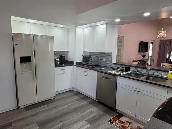 a kitchen with granite countertop a refrigerator and a sink