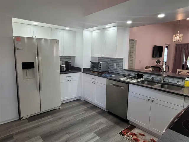 a kitchen with granite countertop a refrigerator and a sink
