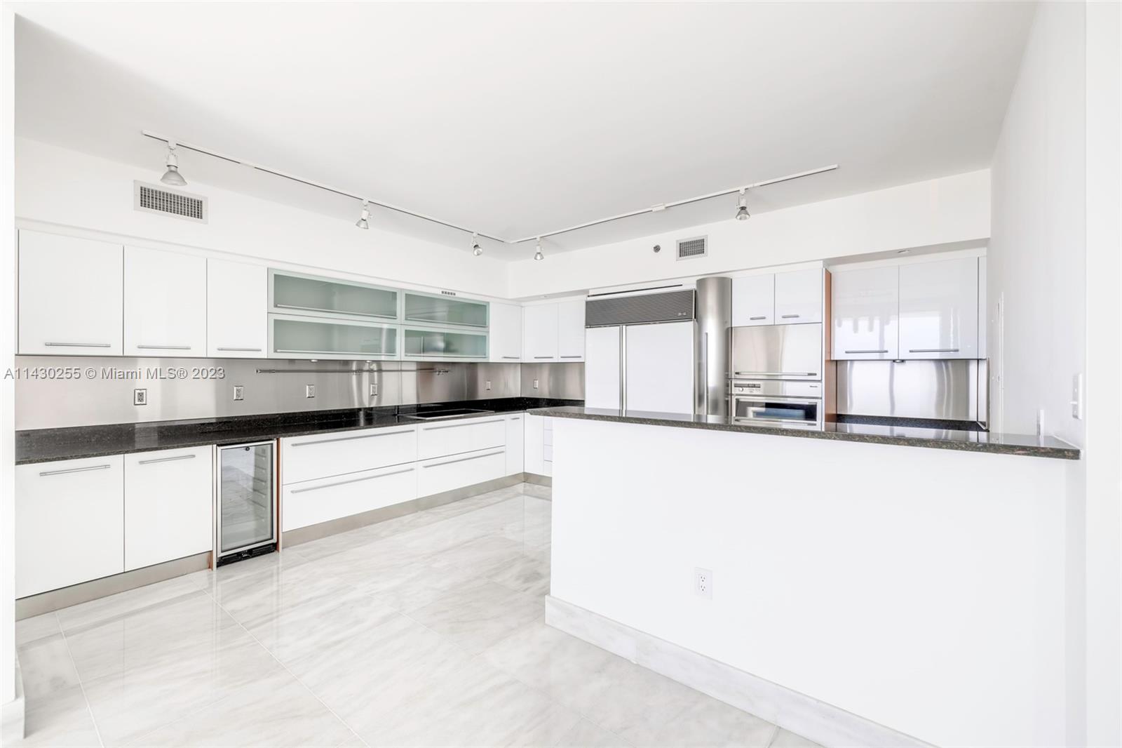 400 Alton Road, Unit 3403 Miami Beach, FL 33139 - Photo 18 of 34 a kitchen with stainless steel appliances a refrigerator and white cabinets
