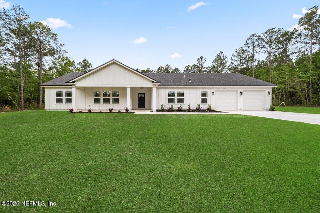 a front view of a house with a garden and trees