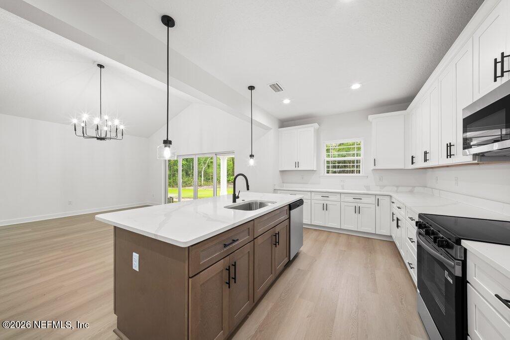 2318 Steel Bridge Road Macclenny, FL 32063 - Photo 12 of 39 a kitchen with a stove window and wooden floor