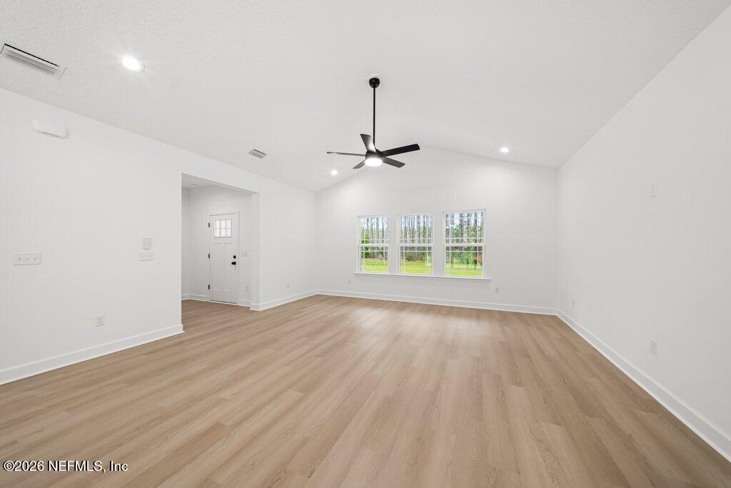 2318 Steel Bridge Road Macclenny, FL 32063 - Photo 15 of 39 an empty room with wooden floor ceiling fan and windows