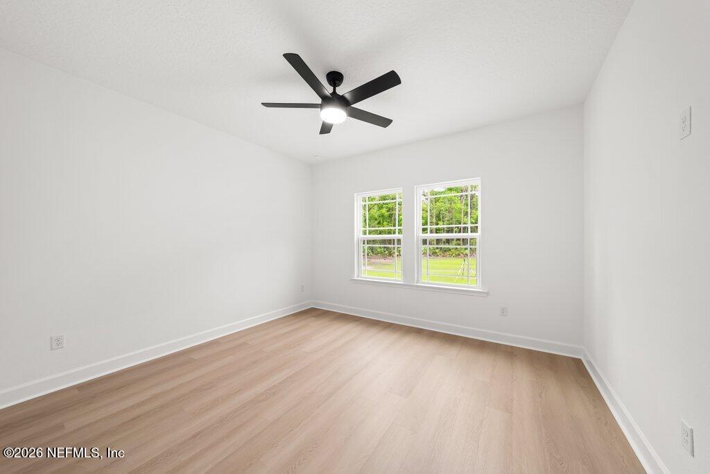 2318 Steel Bridge Road Macclenny, FL 32063 - Photo 29 of 39 an empty room with wooden floor fan and windows