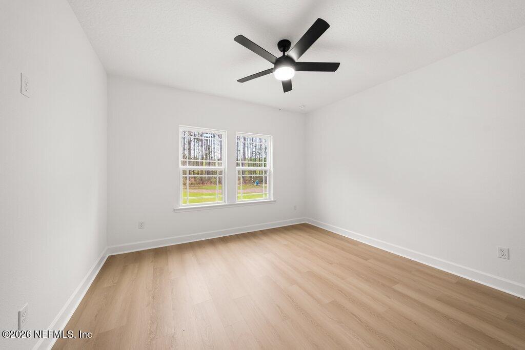 2318 Steel Bridge Road Macclenny, FL 32063 - Photo 32 of 39 an empty room with wooden floor ceiling fan and windows