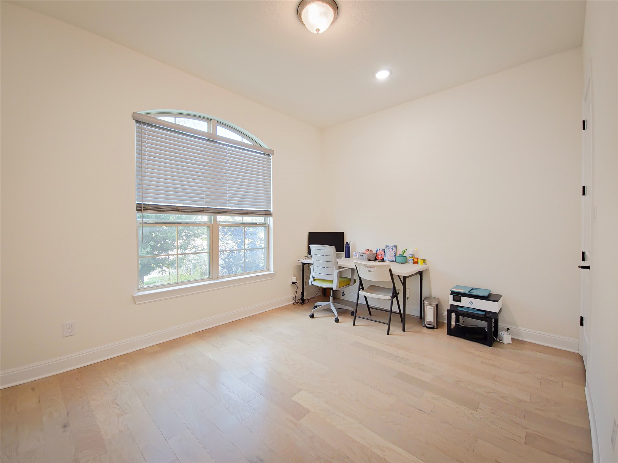 813 Sunny Ridge Drive Leander, TX 78641 - Photo 4 of 32 An arched window brings light into this versatile space with light hardwood flooring.