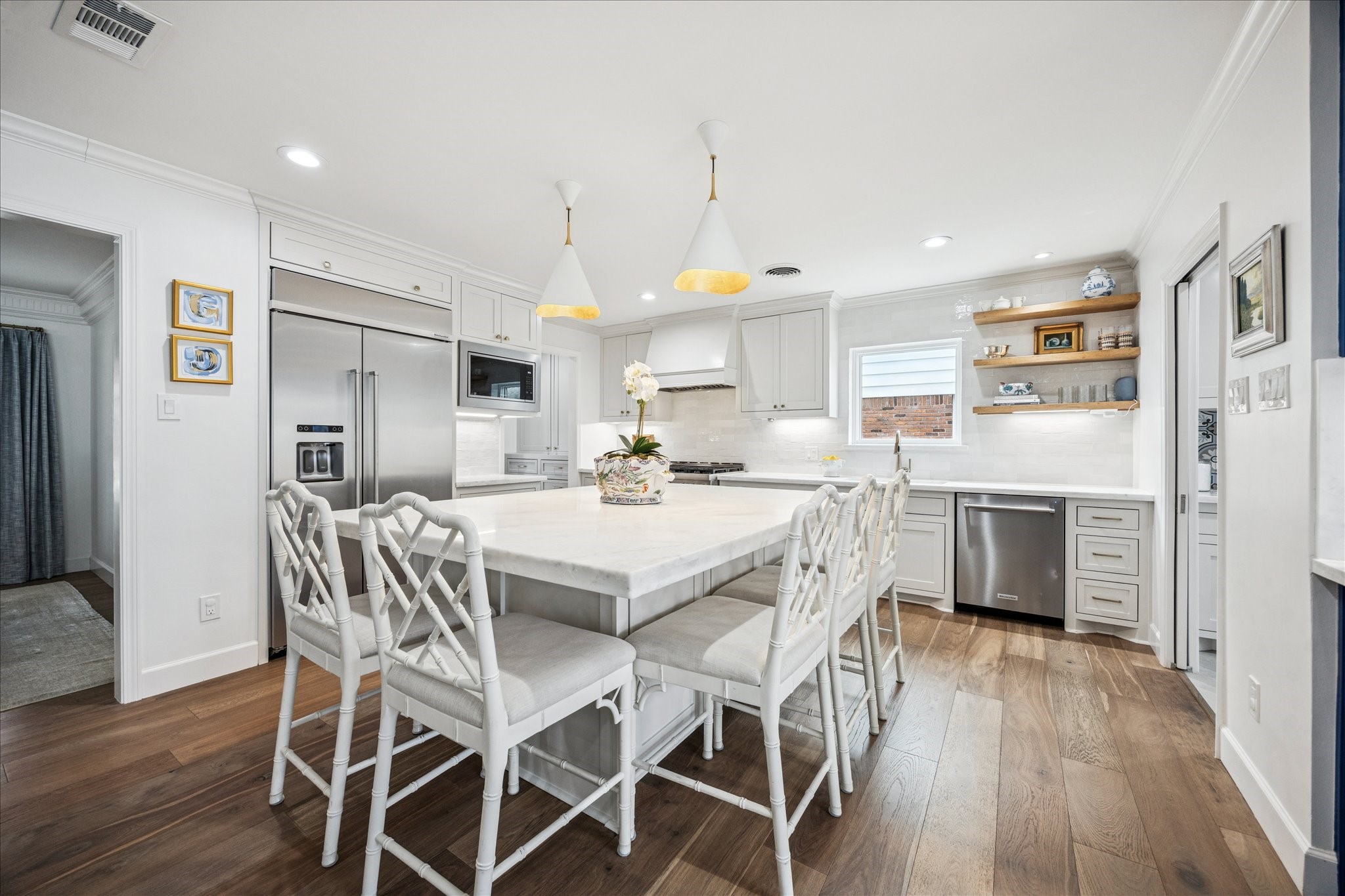 7906 Meadowbriar Lane Houston, TX 77063 - Photo 2 of 34 Gorgeous chef's kitchen with high-end stainless steel appliances, marble counters, built-in KitchenAid refrigerator, and a large island with ample seating and storage.