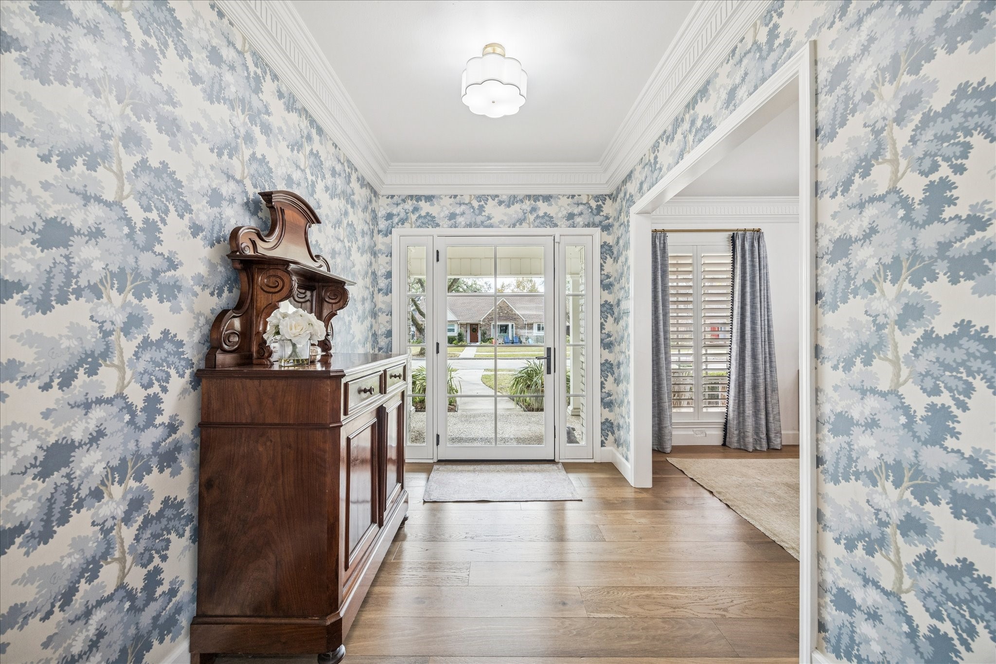 7906 Meadowbriar Lane Houston, TX 77063 - Photo 9 of 34 Entry to the home with Sanberg wallpaper, detailed crown moulding and hardwood floors.