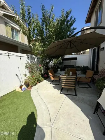 a view of patio with table and chairs under an umbrella