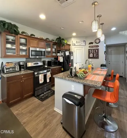 a kitchen with stainless steel appliances granite countertop a stove a sink and a refrigerator