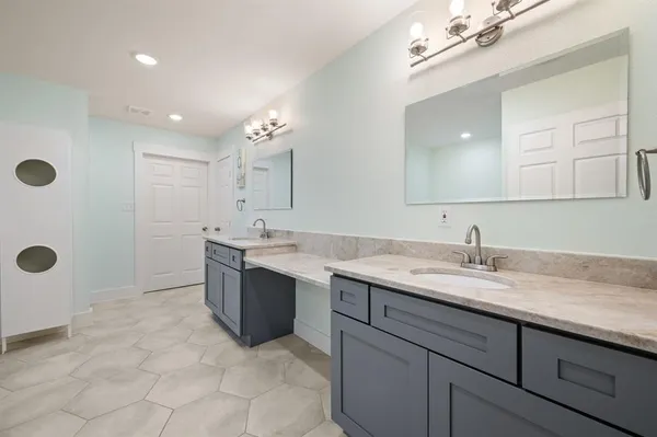 a bathroom with a granite countertop sink a mirror and a shower