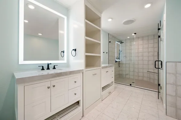 a spacious bathroom with a shower sink and mirror