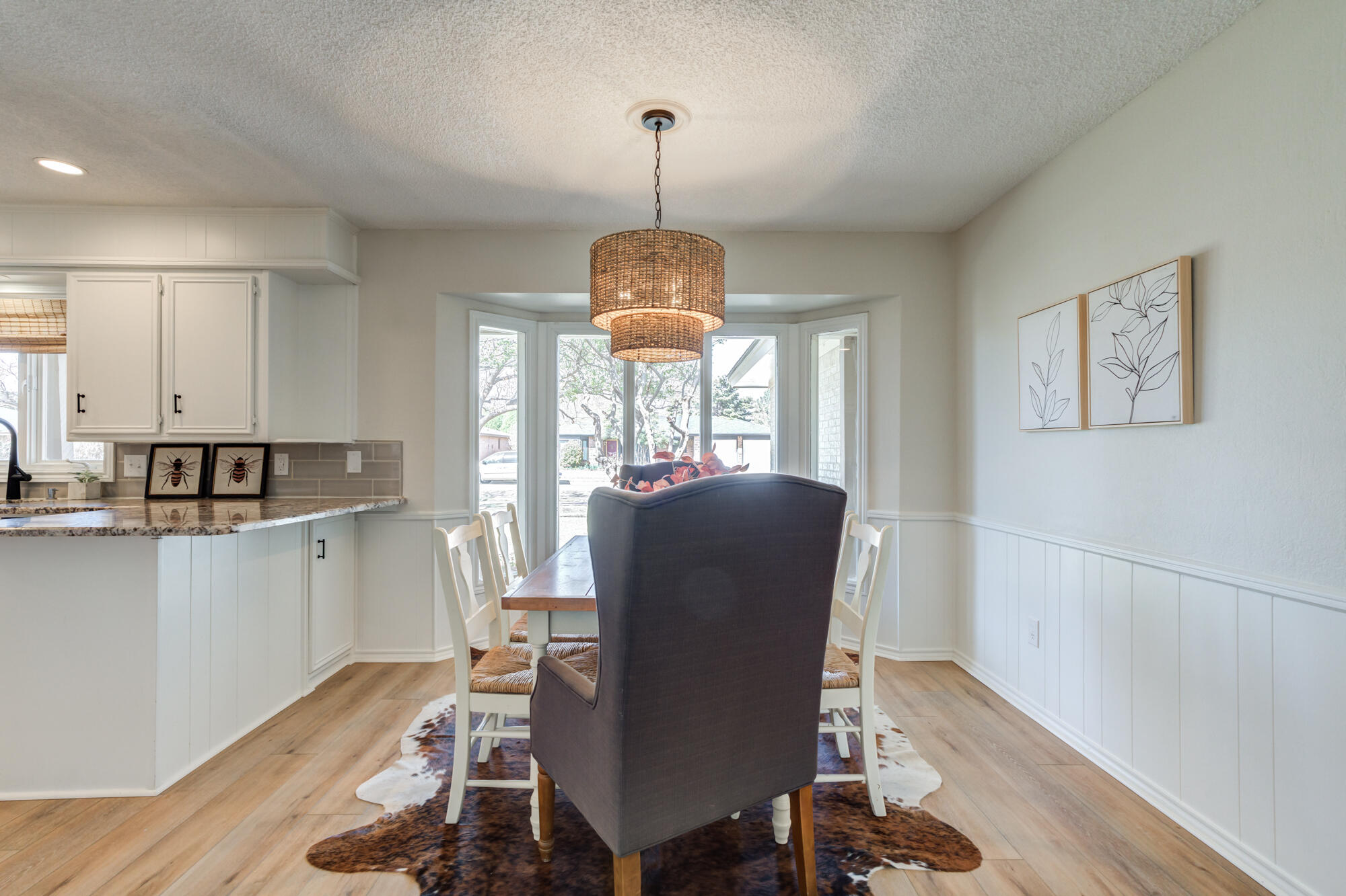 3405 91st Street Lubbock, TX 79423 - Photo 16 of 41 a dining room with wooden floor a chandelier a wooden table and chairs