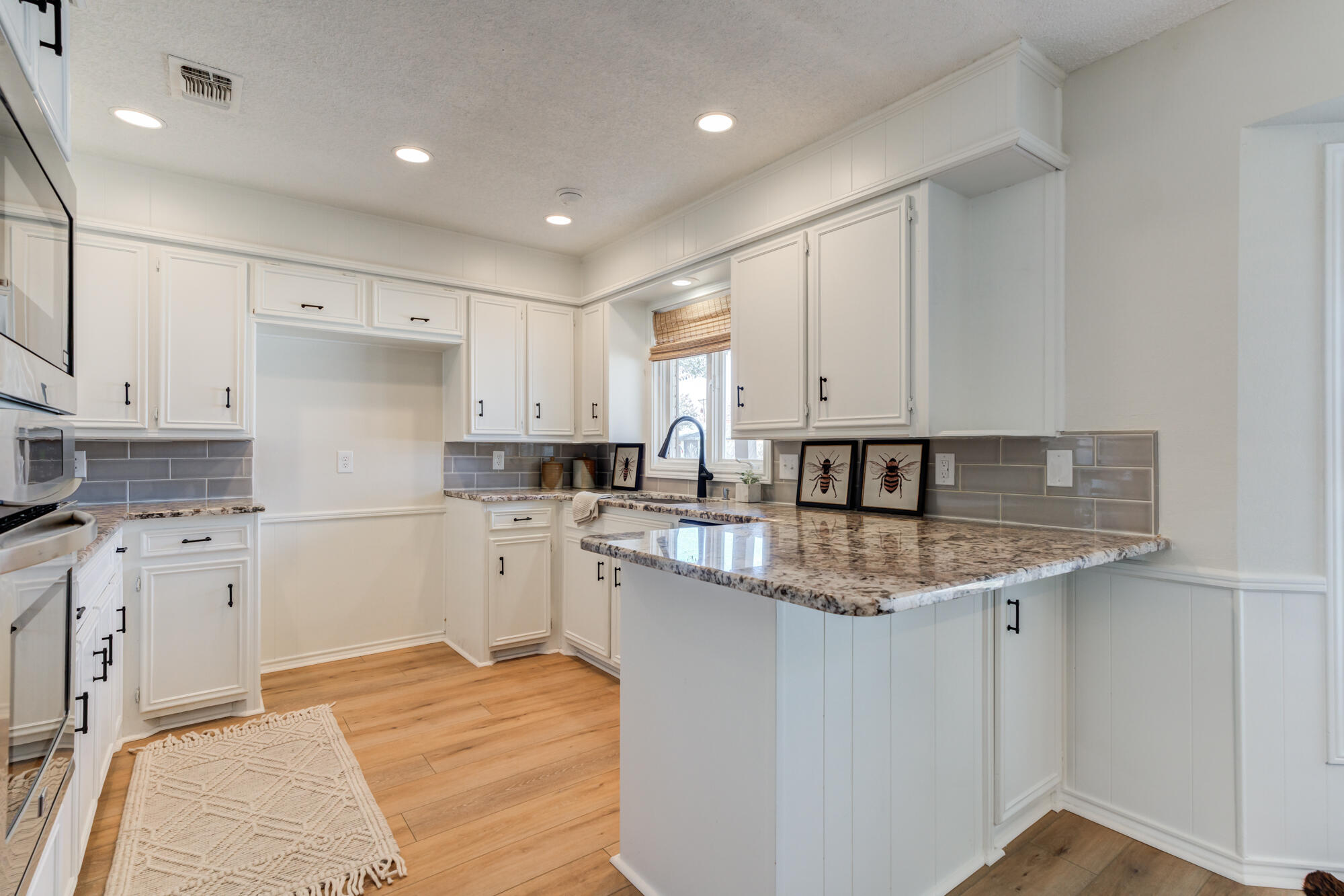 3405 91st Street Lubbock, TX 79423 - Photo 18 of 41 a kitchen with a sink stove and white cabinets