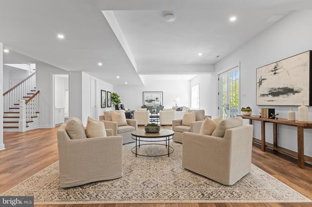 a spacious bedroom with a bed a couch and large window