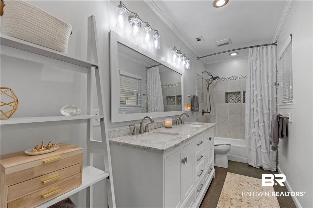 1624 Apex Drive Mobile, AL 36693 - Photo 24 of 29 Full bathroom with vanity, toilet, shower / bath combo with shower curtain, and ornamental molding