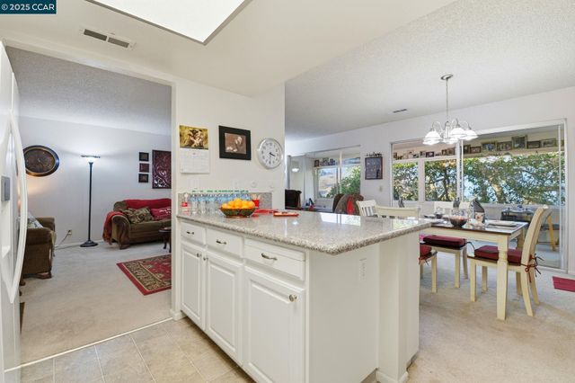 a kitchen with stainless steel appliances kitchen island granite countertop a stove a sink and a microwave