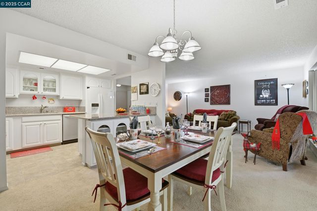 a view of a dining room with furniture and a chandelier