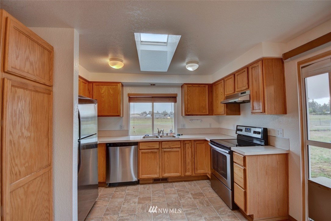 4121 Violet Court Southwest Rochester, WA 98579 - Photo 5 of 21 a kitchen with stainless steel appliances a sink stove and cabinets