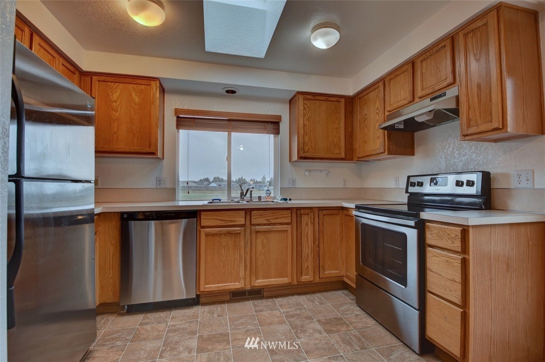 4121 Violet Court Southwest Rochester, WA 98579 - Photo 7 of 21 a kitchen with stainless steel appliances granite countertop a sink stove and cabinets
