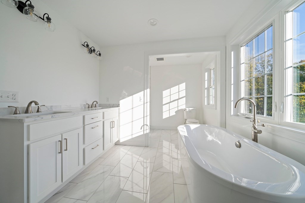 1 Northway Road Randolph, MA 02368 - Photo 30 of 40 a spacious bathroom with a double vanity sink a mirror and a bathtub