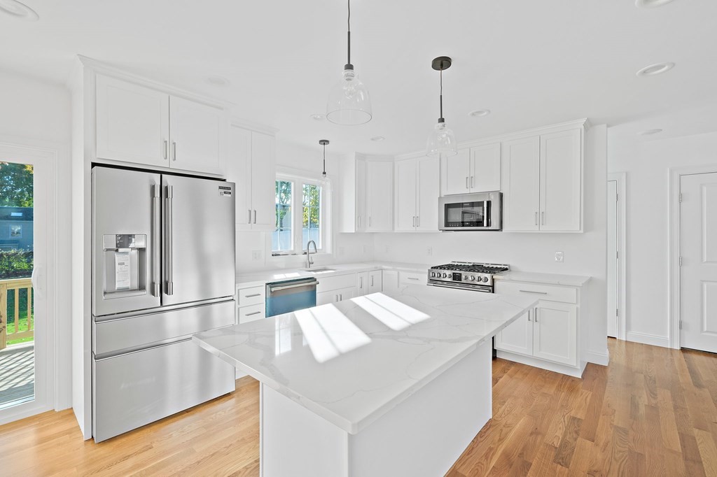 1 Northway Road Randolph, MA 02368 - Photo 7 of 40 a kitchen with white cabinets and stainless steel appliances