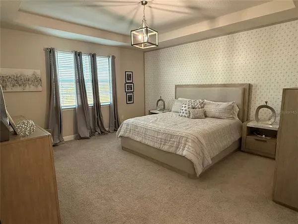 a bedroom with a bed and a chandelier