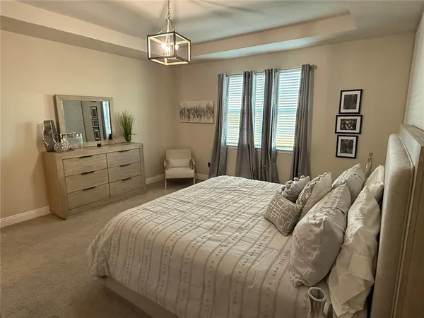 a bedroom with a bed dresser and window