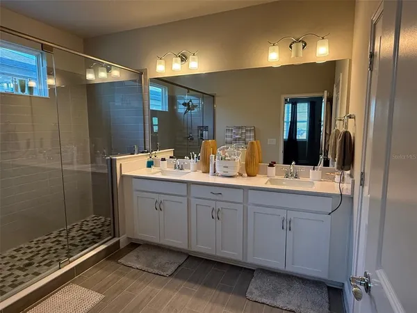 a bathroom with double sink and a mirror