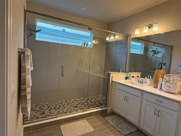 a bathroom with a double vanity sink mirror and shower