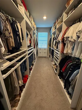 a view of walk in closet with clothes and shoes
