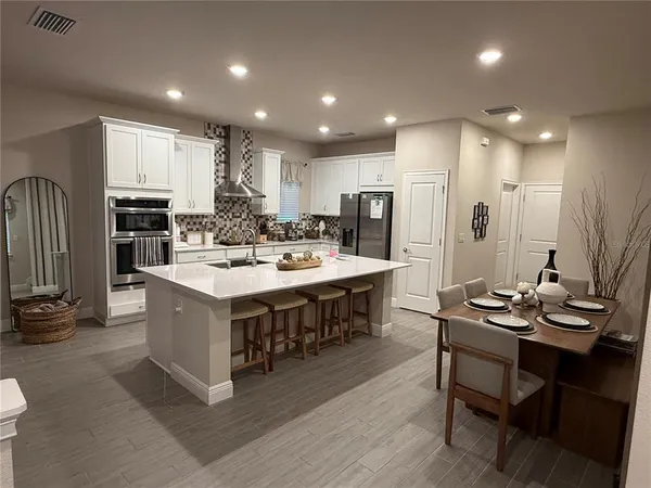a large kitchen with a table and chairs
