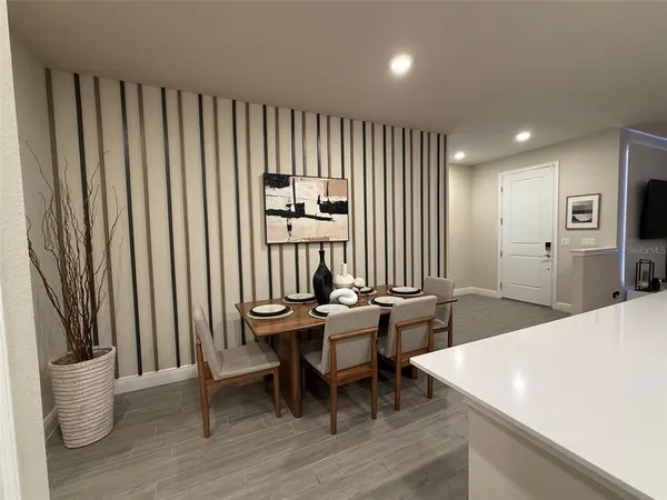 a dining room with furniture and a potted plant