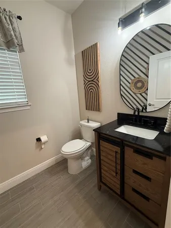 a bathroom with a sink a toilet and mirror