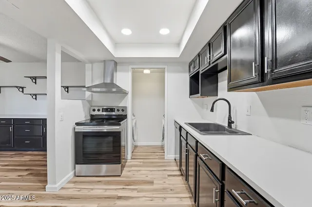 a kitchen with stainless steel appliances granite countertop a sink a stove and a refrigerator