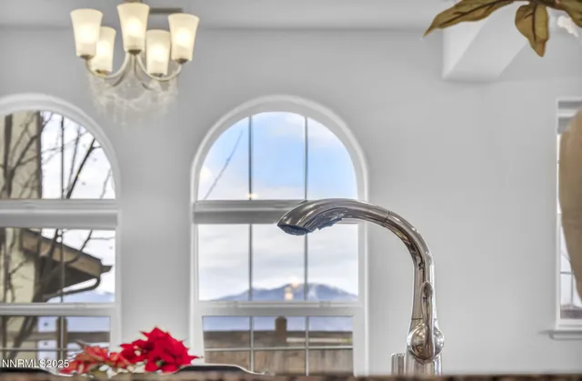 a kitchen with stainless steel appliances granite countertop a dining table chairs and white cabinets
