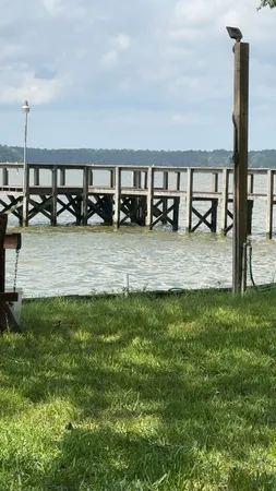 a view of swimming pool with lawn chairs and iron fence