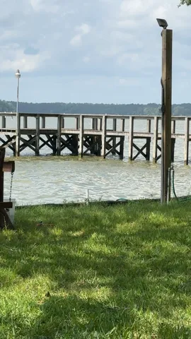 a view of swimming pool with lawn chairs and iron fence