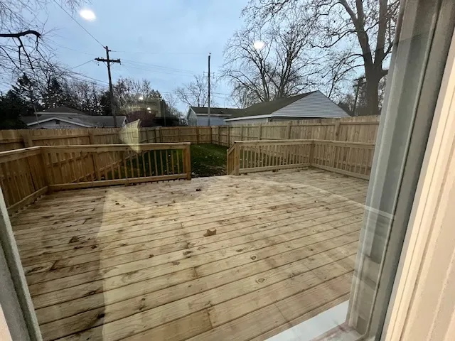 a view of a balcony with wooden floor and fence and a floor to ceiling window