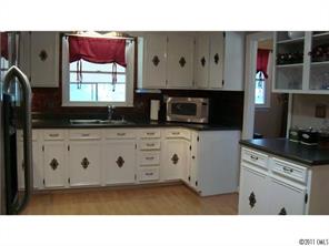 13220 Mayes Road Huntersville, NC 28078 - Photo 3 of 13 a kitchen with stainless steel appliances a stove a microwave and white cabinets