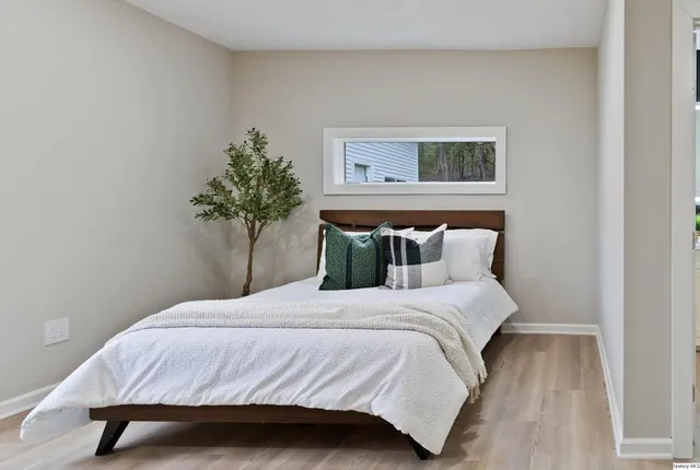a bedroom with a bed and a potted plant