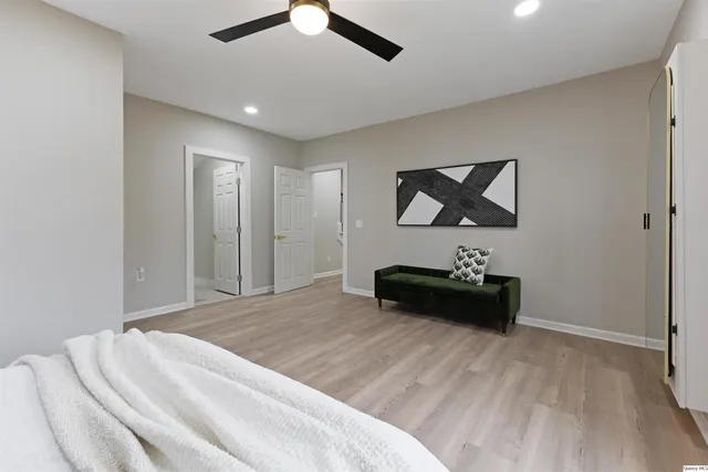 a bedroom with a bed and a painting on the wall