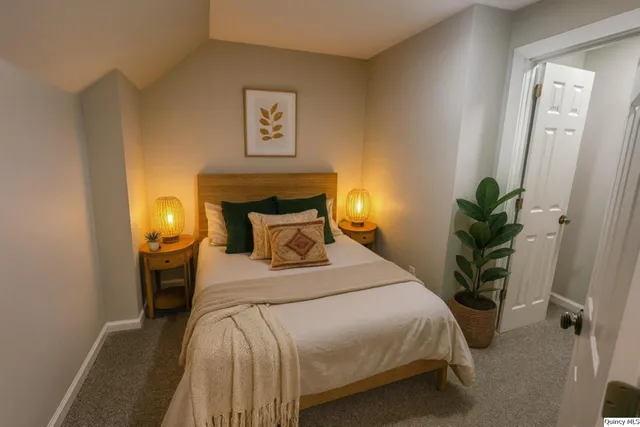 a bedroom with a bed and a potted plant