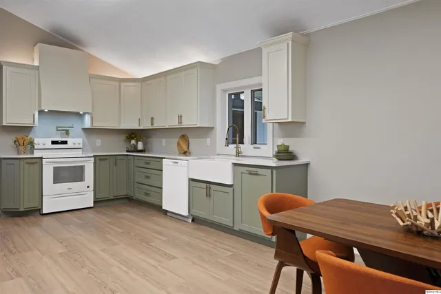 a kitchen with a table chairs sink and cabinets