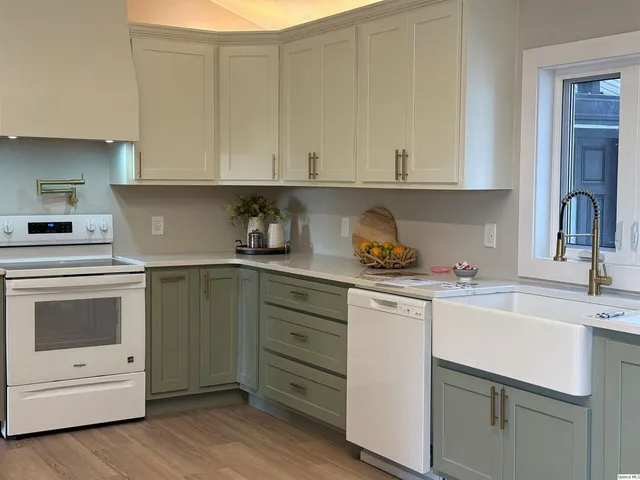 a kitchen with granite countertop white cabinets and white appliances