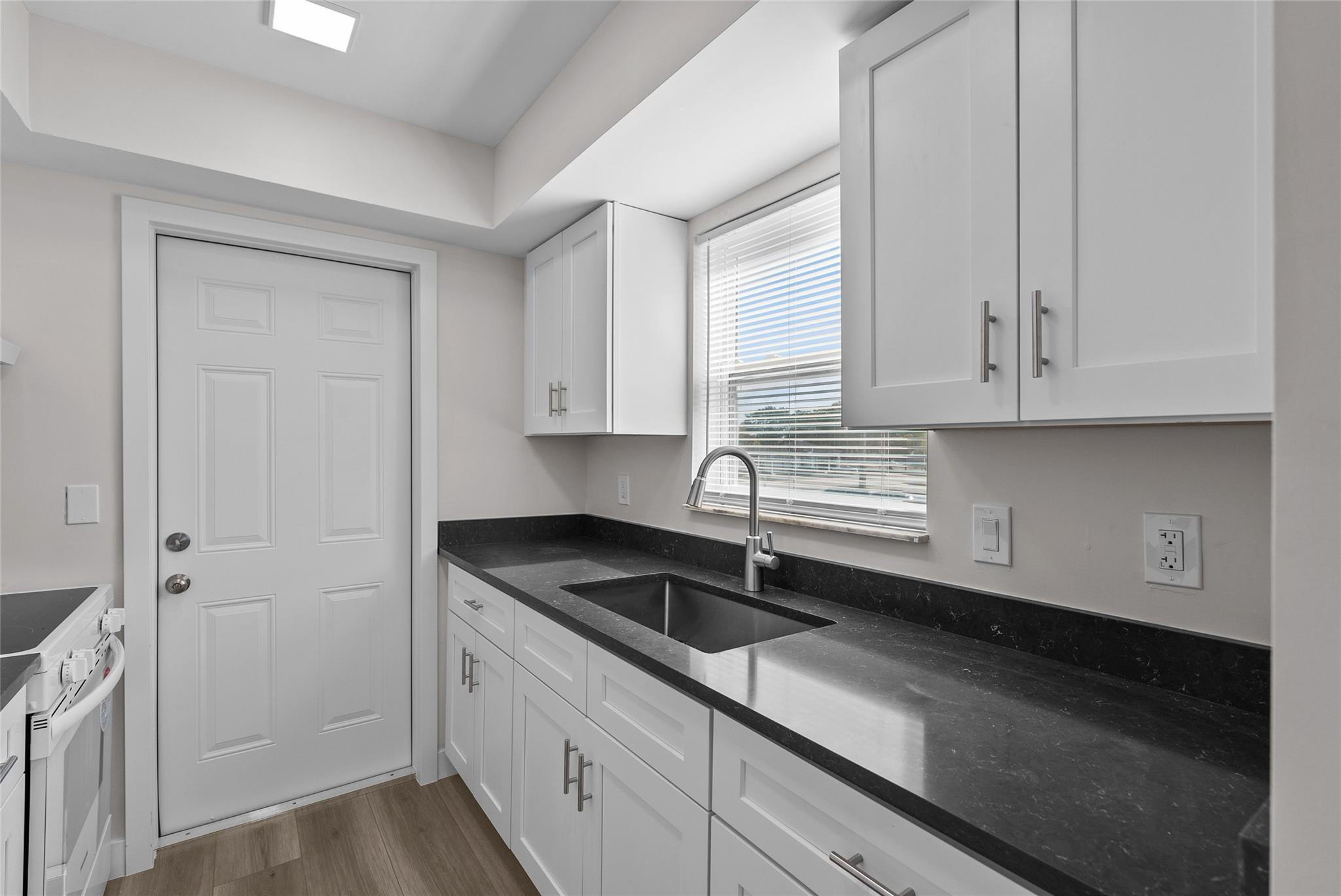 1150 East Sample Road, Unit 202 Pompano Beach, FL 33064 - Photo 3 of 20 a kitchen with stainless steel appliances granite countertop white cabinets and a granite counter tops
