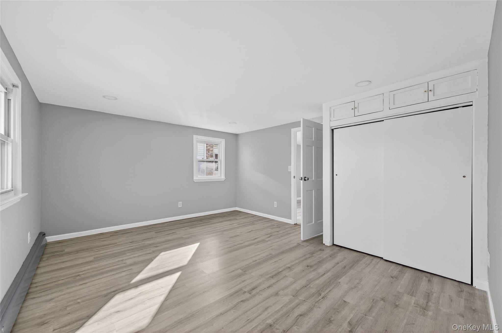 28 Candle Lane Levittown, NY 11756 - Photo 12 of 18 a view of an empty room with wooden floor and a window