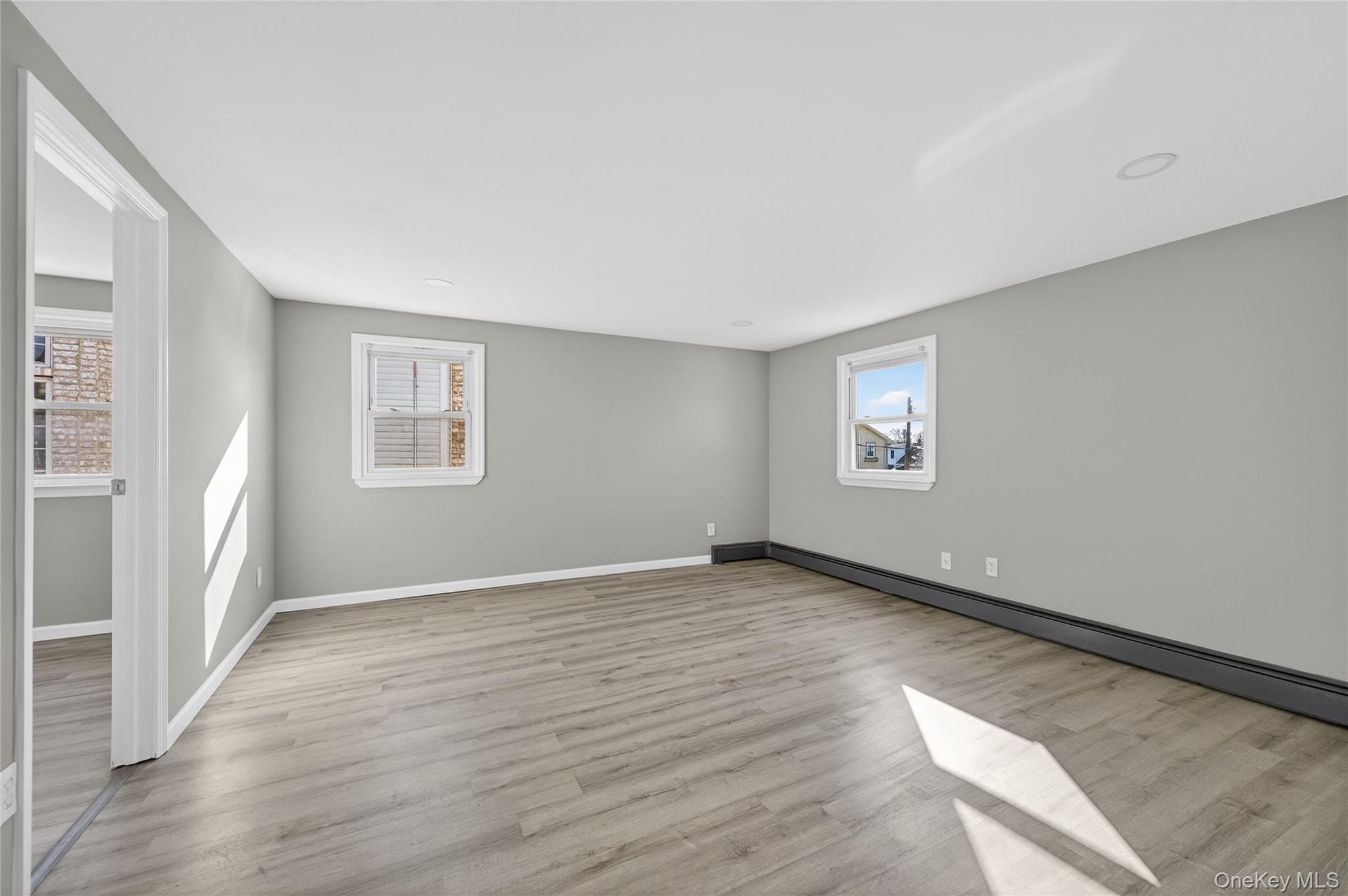 28 Candle Lane Levittown, NY 11756 - Photo 13 of 18 an empty room with wooden floor and windows